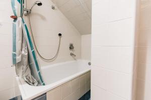 y baño con bañera blanca y ducha. en [Campiglio-Apartment] Free Parking & Self Check-in, en Madonna di Campiglio