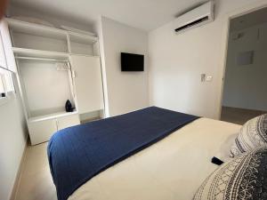 a bedroom with a bed with a blue blanket on it at Sur Suites Palmeras 7 in Fuengirola +25 photos