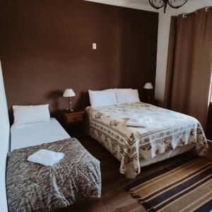 a bedroom with two beds with towels on them at pousada canarinho in Tiradentes