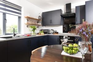 a kitchen with a table with a bowl of apples on it at Bay Dream, St Ives in Carbis Bay