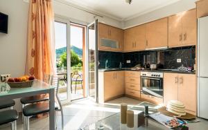 a kitchen with wooden cabinets and a glass table at Emily Apartments in Nydri