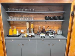 a cabinet with drinks and glasses on top of it at Boutique Hotel La Gorge in Saas-Fee