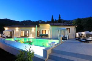 une villa avec une piscine la nuit dans l'établissement Villa Ivana 2, à Starigrad-Paklenica