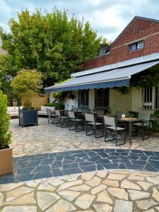 a patio with chairs and tables and a building at Hôtel Le Patio - Deauville in Deauville
