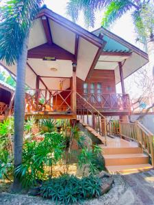 une maison avec des palmiers devant elle dans l'établissement Sila Resort Sukhothai, à Sukhothaï