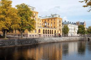 un grande edificio giallo accanto a un fiume di Elite Grand Hotel Gävle a Gävle