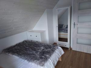 una camera con un letto con una coperta pelosa di DOM PIOTRUSIÓWKA NAD ZALEWEM KLIMKÓWKA a Klimkówka