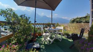 a table and chairs under an umbrella on a patio at la Casa di FrAnto Appartamento in Saint-Christophe