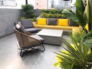 a patio with a couch and chairs and plants at The Hotel Nicecy in Ho Chi Minh City
