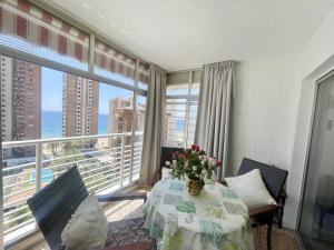 jadalnia ze stołem i dużym oknem w obiekcie Eleven Caballos Apartment w mieście Benidorm