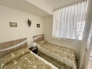 sypialnia z dwoma łóżkami i oknem w obiekcie Eleven Caballos Apartment w mieście Benidorm +12 zdjęć