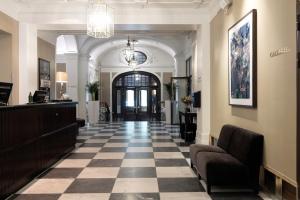 una hall con pavimento a scacchi e un salone di Elite Grand Hotel Gävle a Gävle