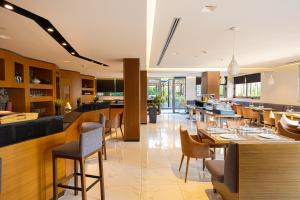 un ristorante con tavoli e sedie e un bar di Andon Lapa Hotel & Spa a Sarandë