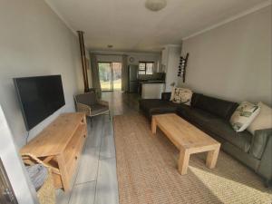 a living room with a couch and a tv at The Dock in Clarens