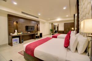 a hotel room with two beds and a television at Cygnett Inn Trendz in Itānagar