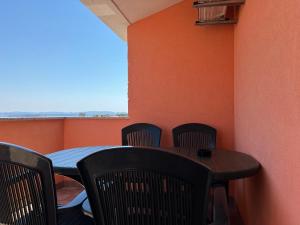 a table and chairs in a room with an orange wall at Apartmani Kovačić in Kraj