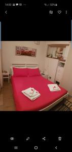 a red bed with two towels on top of it at Il Daviduccio in Catania