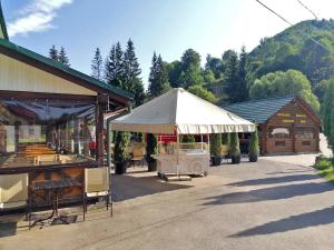 un marché avec une tente blanche à côté d'un bâtiment dans l'établissement Хостел Васкул, à Kvasy