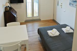 Una habitación con una cama y una mesa con toallas. en Alloggio ad uso turistico - The Apartment n.1, en Anguillara Sabazia