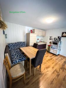 um quarto com uma mesa e uma cozinha com uma mesa e cadeiras em Strandhussiedlung Rügen em Dranske