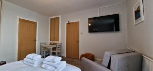 a hotel room with a bed and a flat screen tv at Woodland Family Apartment With Electric Car Point in Windermere