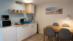 uma pequena cozinha com uma mesa e uma sala de jantar em Strandhussiedlung Rügen em Dranske