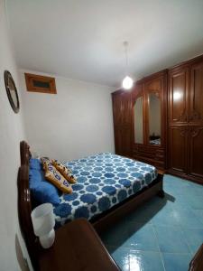 um quarto com uma cama com almofadas em La casa tra il verde e il blu em Lipari