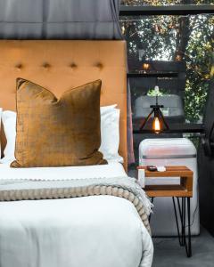 um quarto com uma cama com uma cabeceira em madeira e uma mesa em The Tsitsikamma Pyramid em Stormsrivier