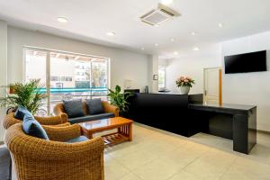 ein Wohnzimmer mit einer Couch und einem Klavier in der Unterkunft Vibra Calima Apartamentos - Adults only in Sant Antoni de Portmany