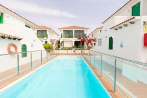 een zwembad op de binnenplaats van een gebouw met een huis bij Las Burrras Buigues Beach in San Bartolomé