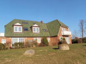 uma grande casa de tijolos com um telhado verde em Haus Jenny, Wohnung E3b, Sonne rundum em Boltenhagen