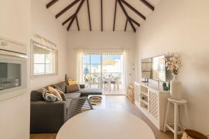 ein Wohnzimmer mit einem Sofa und einem Tisch in der Unterkunft SUNSHINE HOLIDAYS HOME , Playa de Fañabe in Adeje