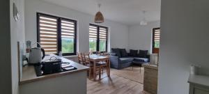 a kitchen and living room with a couch and a table at ŁOMIANKOWA DOLINA Wetlina 112 in Wetlina