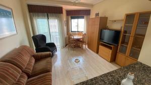 a living room with a couch and a table at Apartamento Playa Samil in Vigo