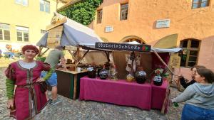 uma mulher em pé em frente a um mercado com uma mesa em Hotel Cranach-Herberge City Centre em Wittenberg