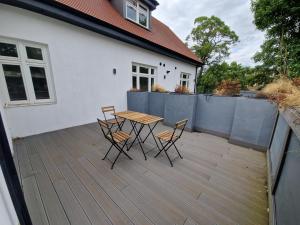 a wooden table and chairs on a wooden deck at 2 Bedroom Lux Apartment in Hendon- New Build in Colindale