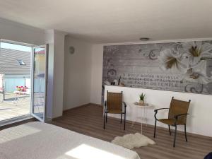 a bedroom with two chairs and a table and a wall with flowers at Ferienhaus Evelina in Steinheim +25 photos