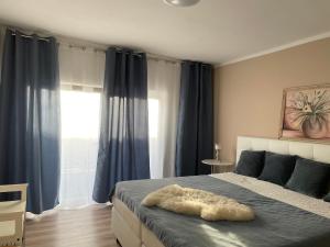 a bedroom with a large bed with blue curtains at Ferienhaus Evelina in Steinheim +13 photos