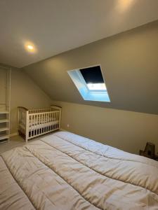 a large bed in a bedroom with a baby crib at La Maison Bleue, proche de tout in Le Tréport
