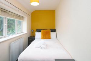 a bedroom with two beds and a yellow wall at The Cresent WV1 - 3 Bedroom House, Table Soccer, Parking, Garden in Monmore Green