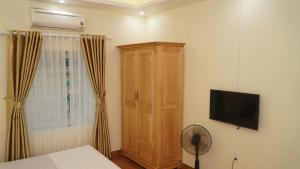 1 dormitorio con armario de madera y TV en NK Công Đoàn Hải Dương en Hải Dương