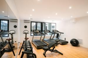 a gym with several treadmills and elliptical machines at The Nicolaus Hotel in Bari