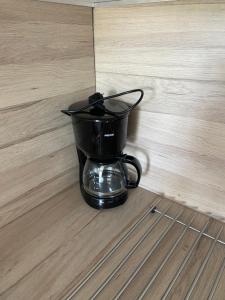 a black coffee maker sitting on the floor at Vue mer et verdure in Villers-sur-Mer