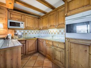 uma cozinha com armários de madeira e um aparelho branco em Appartement Courchevel 1850, 4 pièces, 6 personnes - FR-1-564-30 em Courchevel