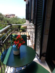 una mesa con un jarrón de flores en el balcón en Skardamoula's Studios and Apartments, 2, en Kardhamili