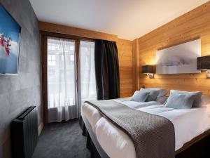 a hotel room with a large bed and a window at Appartement Courchevel 1850, 4 pièces, 6 personnes - FR-1-564-42 in Courchevel