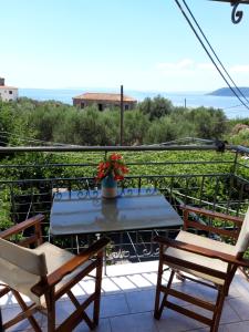 een patio met een tafel en stoelen op een balkon bij Skardamoula's Studios and Apartments, 2 in Kardhamili