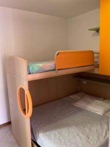 an orange bunk bed in a small room at Villaggio dei Fiori Apart- Hotel 4 Stars - Family Resort-Petz Friendly-With Hypermarket-Delivery Restaurant-Pizzeria-With Breakfast Room with Supplement in Caorle