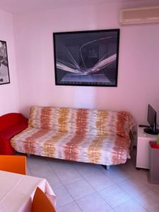 sala de estar con sofá y TV de pantalla plana en Villaggio dei Fiori Apart- Hotel 4 Stars - Family Village Petz Friendly, en Caorle