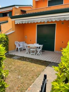 un patio con mesa y sillas frente a un edificio en Villaggio dei Fiori Apart- Hotel 4 Stars - Family Village Petz Friendly, en Caorle